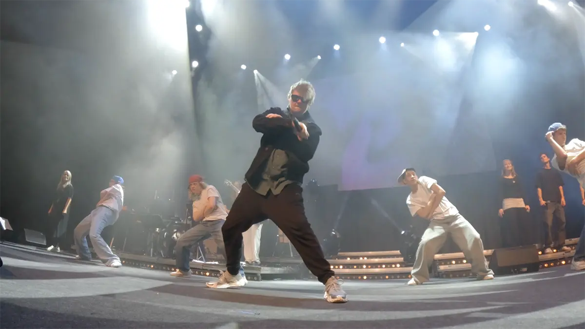 Johan Hellberg uppträder på scenen omgiven av dansare.