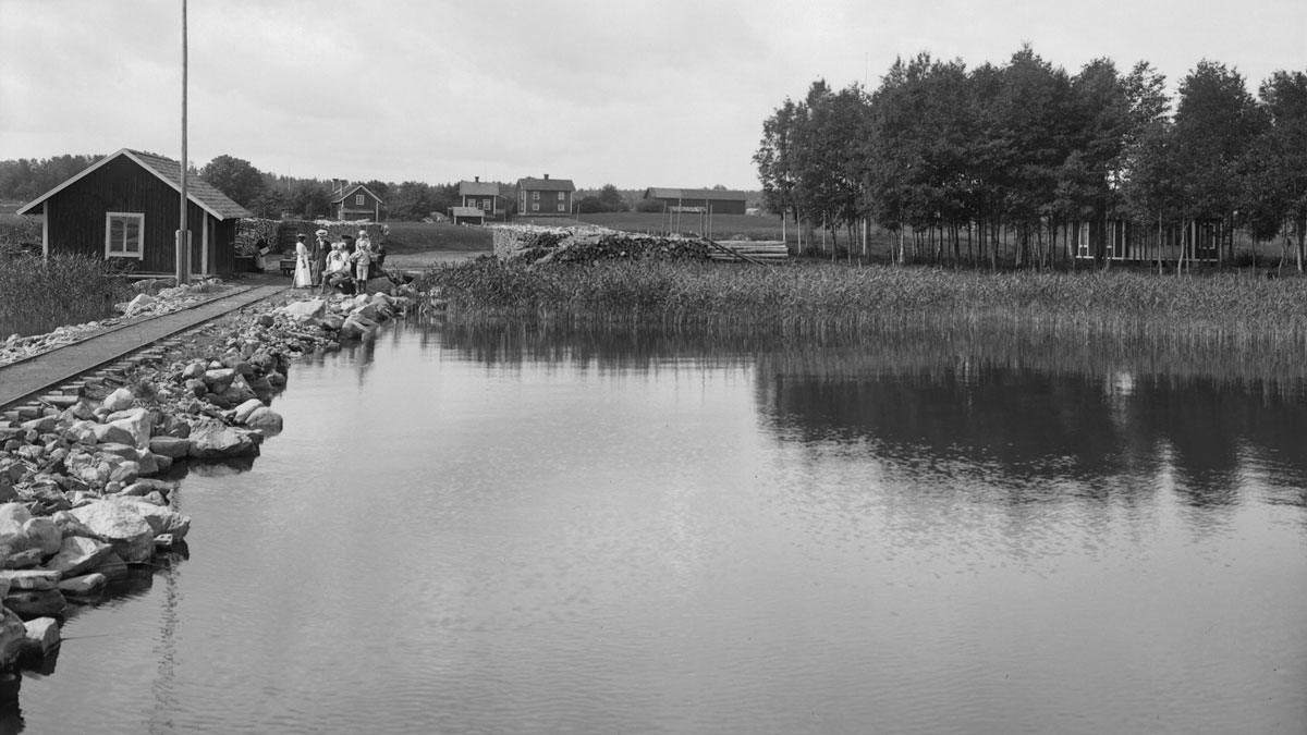 Ångbåtshamnen i förgrunden och gårdsbebyggelsen i fonden, kring sekelskiftet 1900. Örebro Länsmuseum, foto Samuel Lindskog.