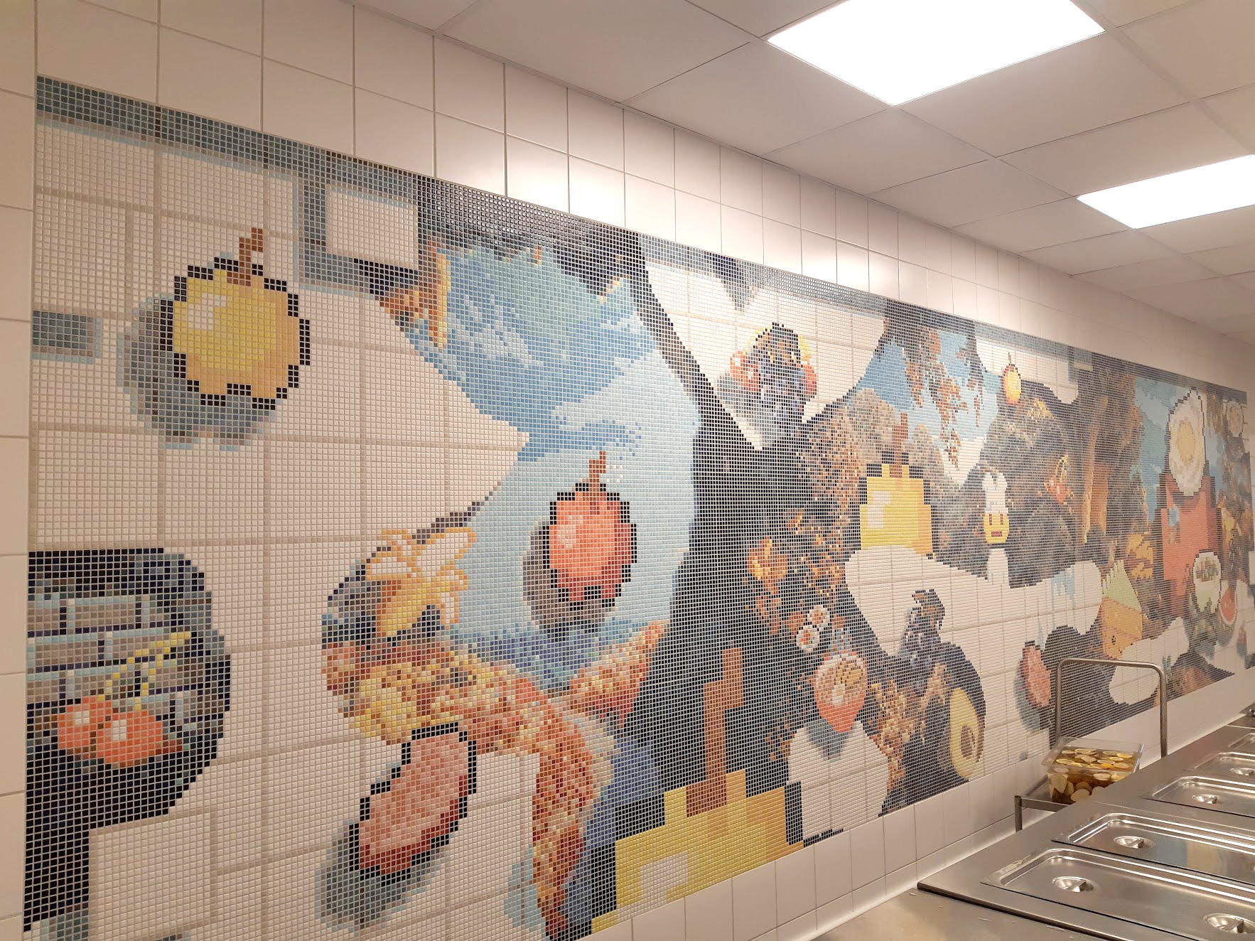 Mosaik på en vägg i en skolmatsal.