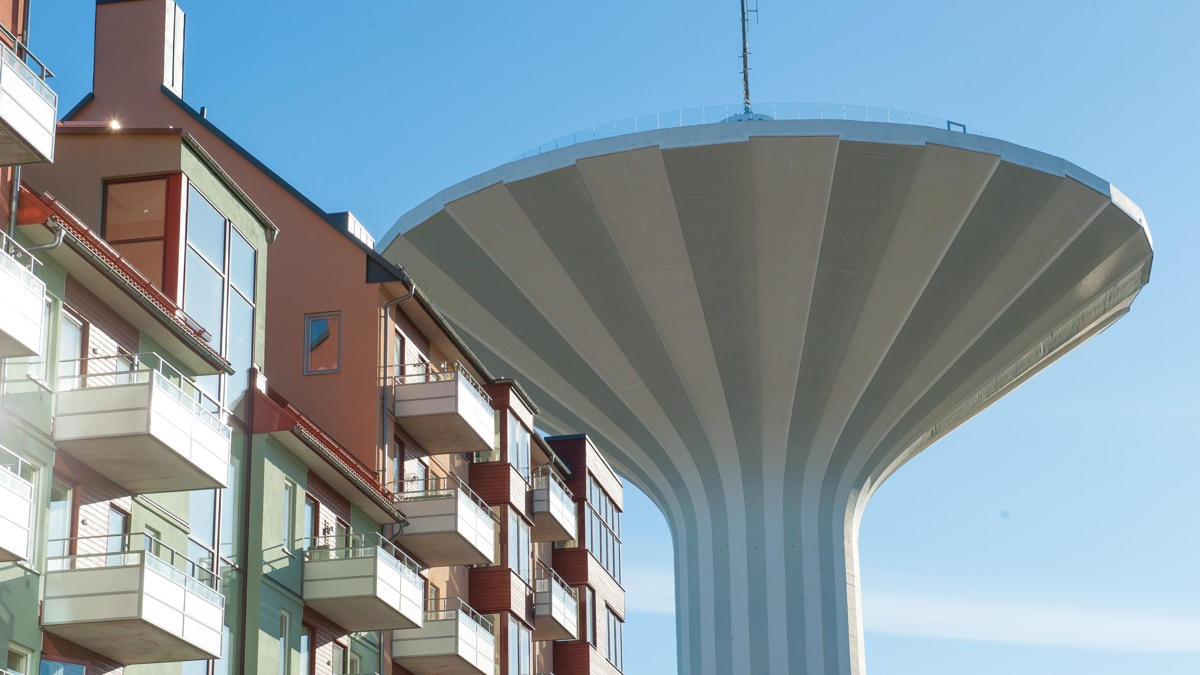 En hög byggnad med ett vattentorn i bakgrunden.
