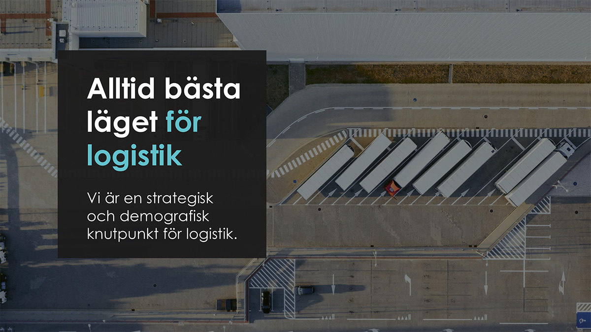 Flygbild av en logistikanläggning med lastbilar parkerade vid en terminal. På vänster sida finns en mörk textruta med budskapet: "Alltid bästa läget för logistik. Vi är en strategisk och demografisk knutpunkt för logistik.
